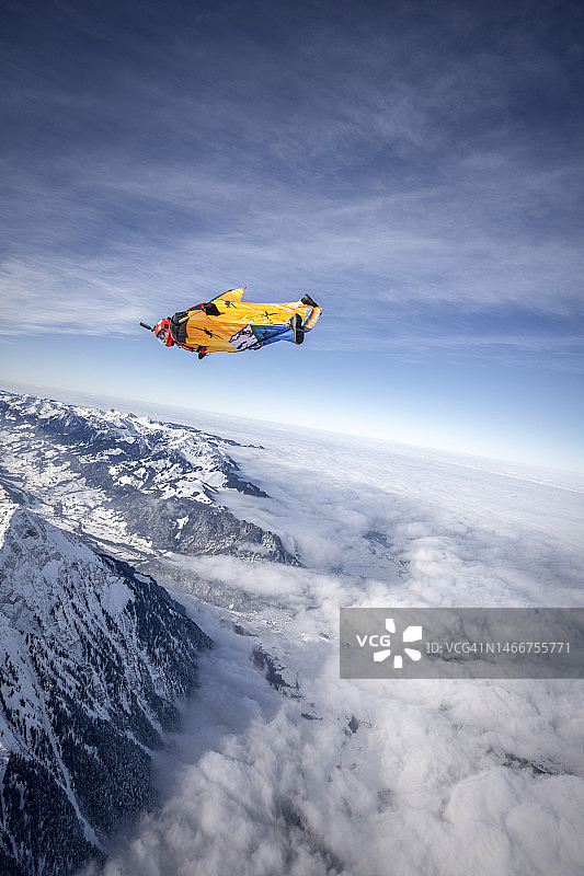 冬天，翼装飞行员在高山上空翱翔图片素材