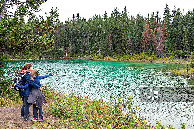 母亲和女儿在加拿大贾斯珀国家公园的五湖谷徒步旅行中欣赏美丽的风景图片素材