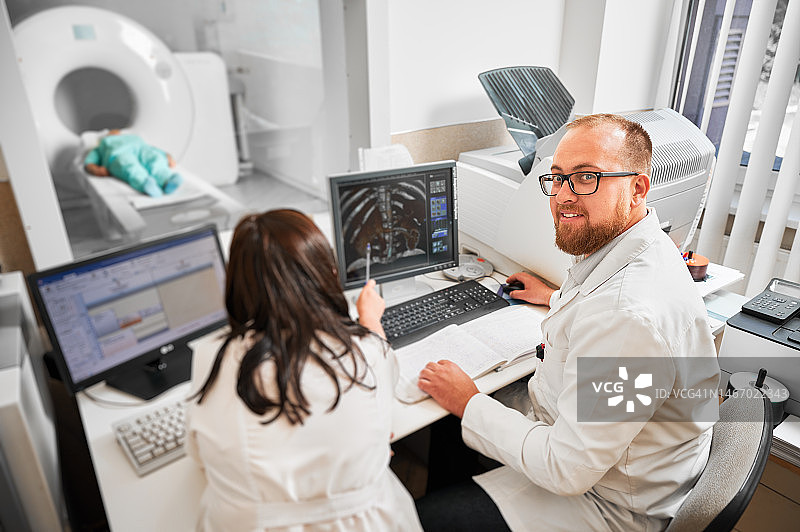 两位医生坐在电脑前，看核磁共振结果。图片素材