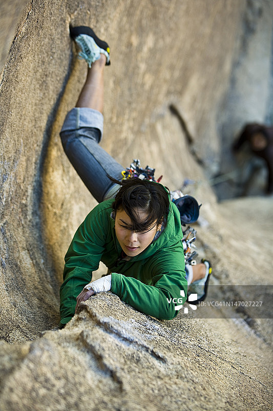 女性攀登者紧紧抓住悬崖。图片素材