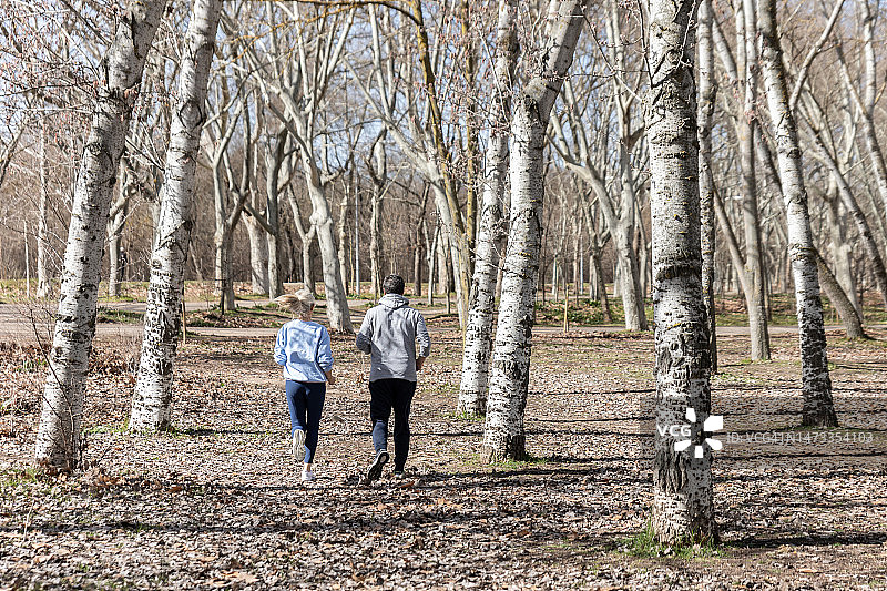 一对陌生的情侣在秋天的森林里奔跑图片素材