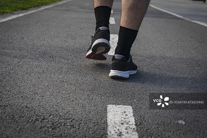 男人跑步脚穿运动鞋。图片素材