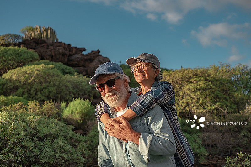 微笑的老夫妇享受户外远足山区环境。美丽活泼的老人在徒步旅行中拥有健康的生活方式图片素材
