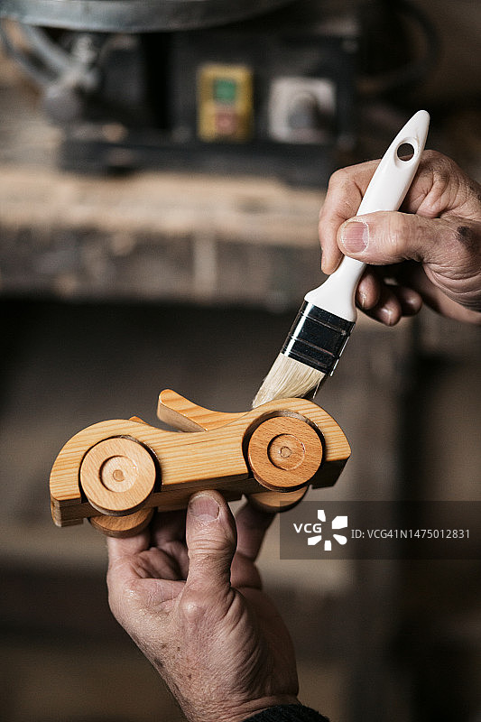 用清漆保护木制汽车玩具的特写。图片素材