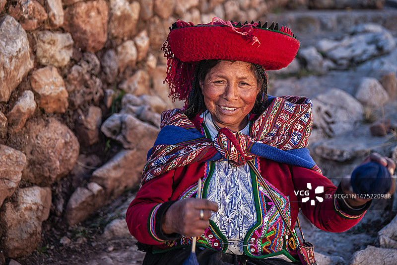 秘鲁圣谷，一名秘鲁妇女用手纺线图片素材