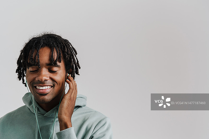 兴奋的年轻非洲男子听音乐与耳机隔离图片素材