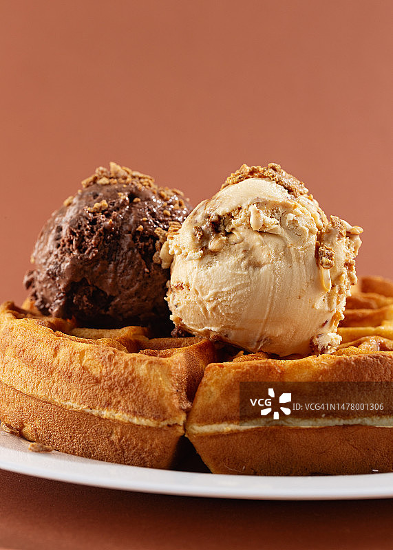 两勺巧克力和焦糖冰淇淋加比利时华夫饼，特写，棕色背景图片素材