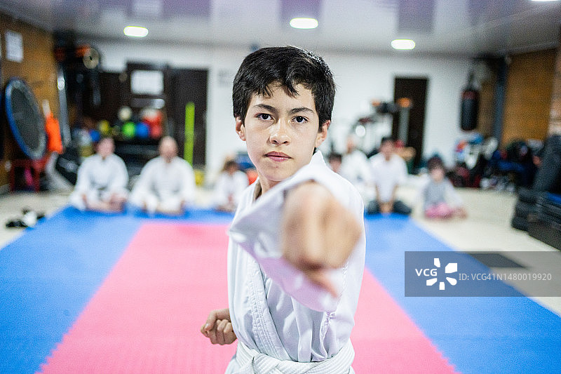 一个小男孩在空手道课上挥拳的样子图片素材