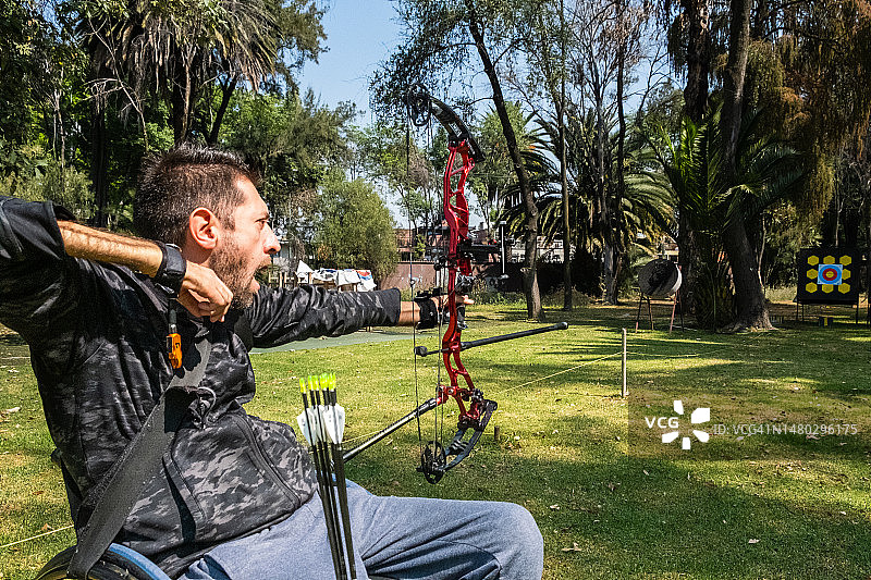一个拉丁裔残疾人，坐在轮椅上，瞄准，练习射箭运动——墨西哥城，墨西哥图片素材
