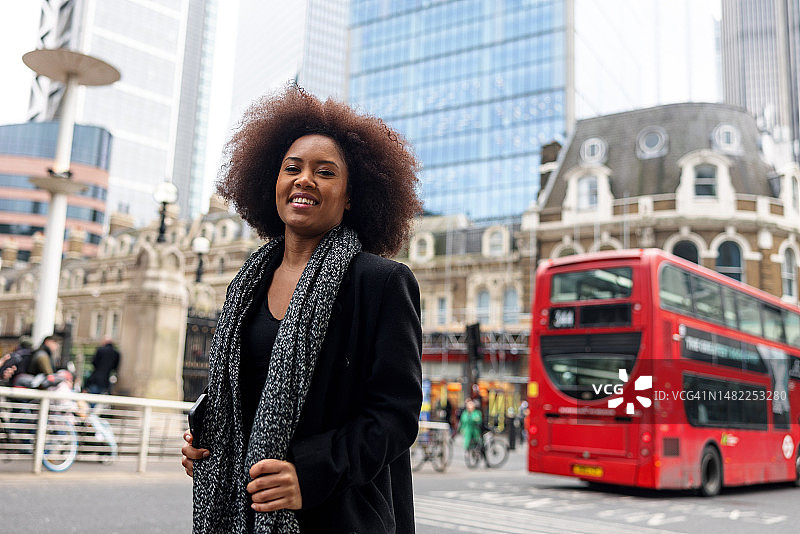 一个快乐的成年黑人女商人在伦敦闲逛，独自探索这座城市图片素材