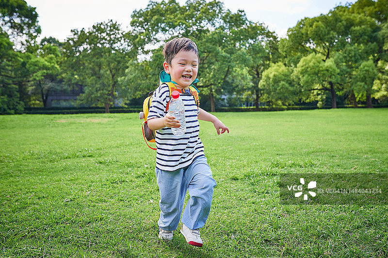 小男孩在草坪上奔跑图片素材