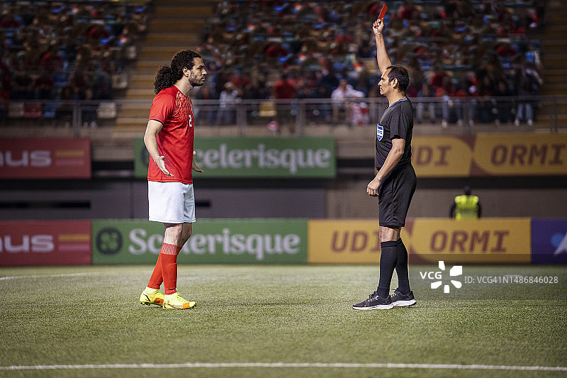 在一场足球比赛中，由于球员与裁判发生争执，裁判判罚红牌图片素材