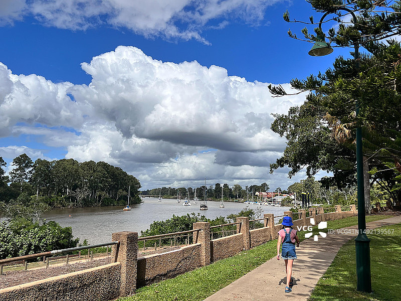 年轻的澳大利亚女孩沿着澳大利亚昆士兰州玛丽堡的玛丽河散步图片素材