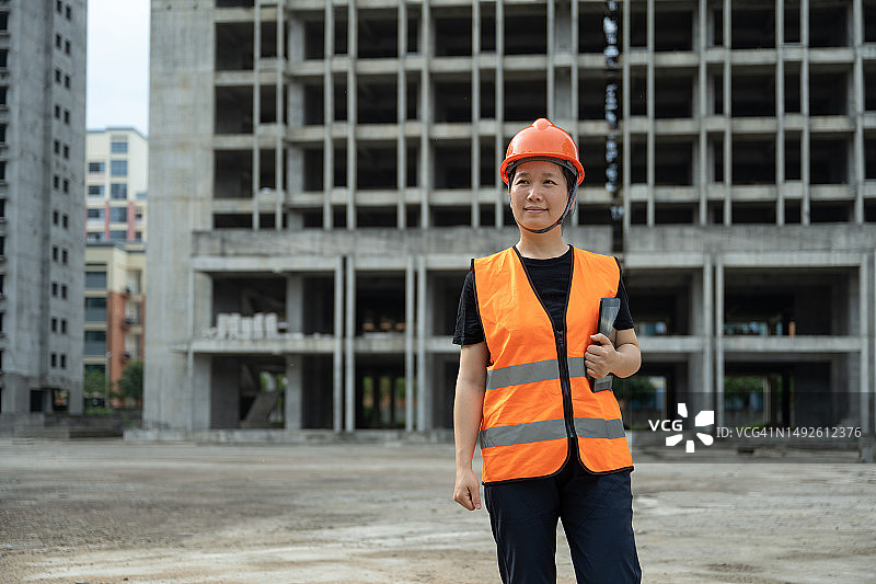 一位中国女工程师在一个新的建筑工地使用平板电脑工作图片素材