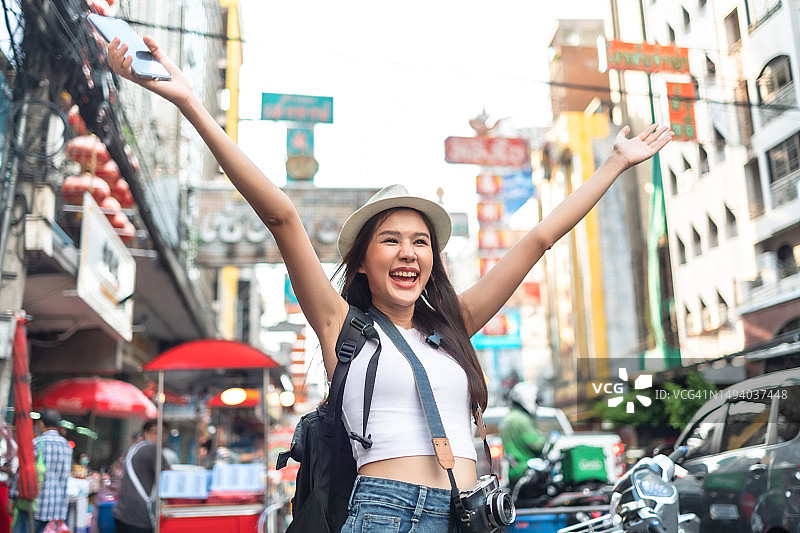 年轻的成年亚洲女性背包旅行者走在唐人街。旅游女孩们正在享受曼谷美丽的地方。图片素材