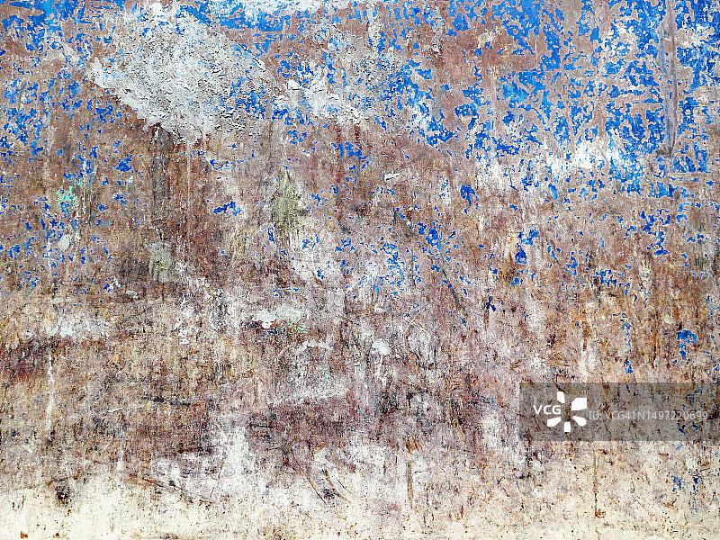 在法国巴黎，一块生锈的金属板上，被风化和刮伤的白色和蓝色油漆上有水泥的痕迹图片素材