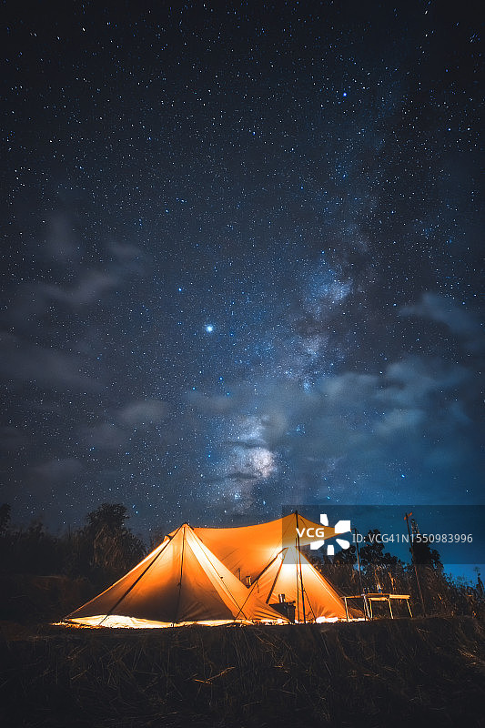 夜间露营在银河下，户外篝火在风景优美的荒野。图片素材