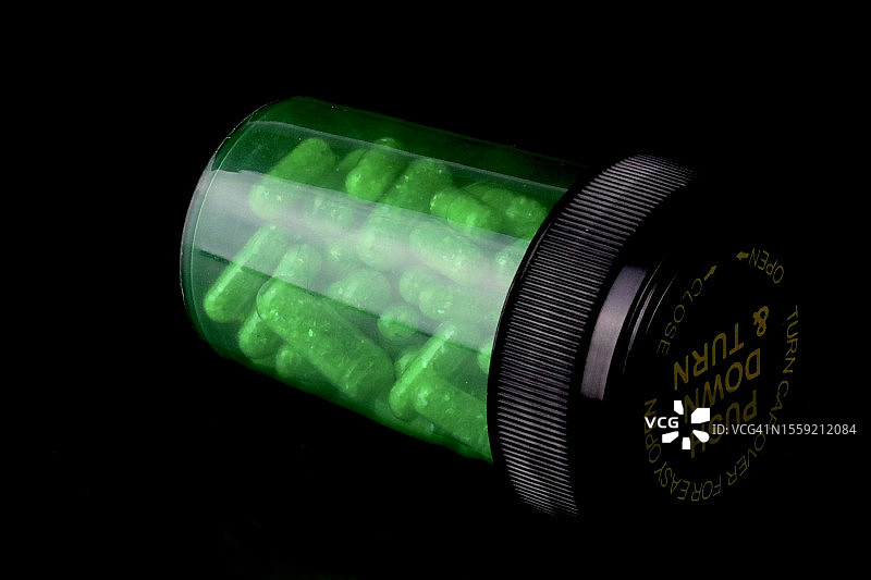 处方胶囊，装在绿色药瓶里图片素材