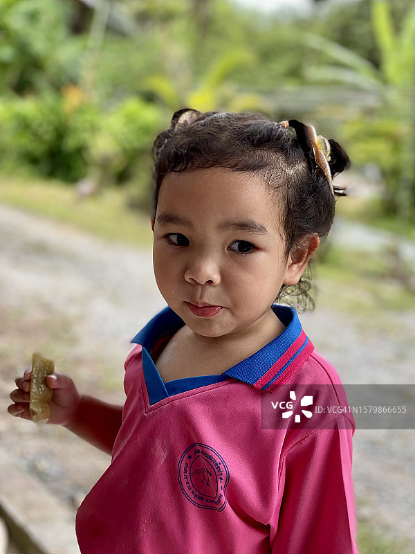 亚洲小女孩吃着用香蕉包着的糯米图片素材