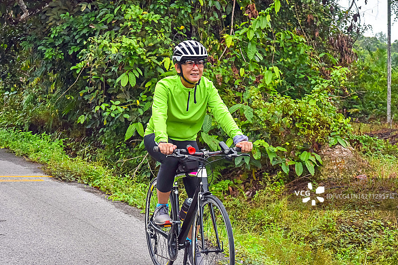 在农村骑自行车的亚洲妇女图片素材
