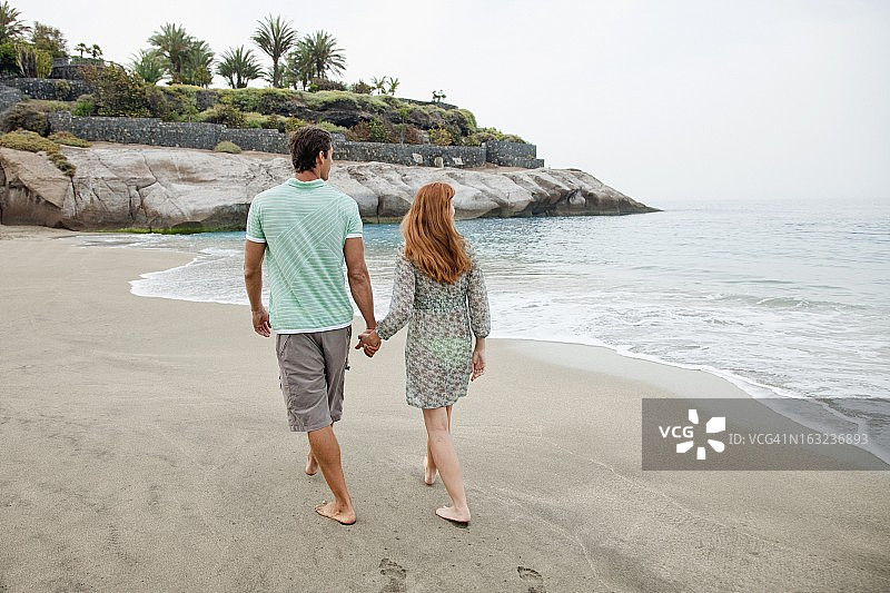 一对情侣在海滩上散步图片素材