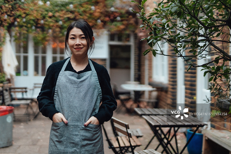 街边咖啡馆自信的亚洲女老板的肖像图片素材