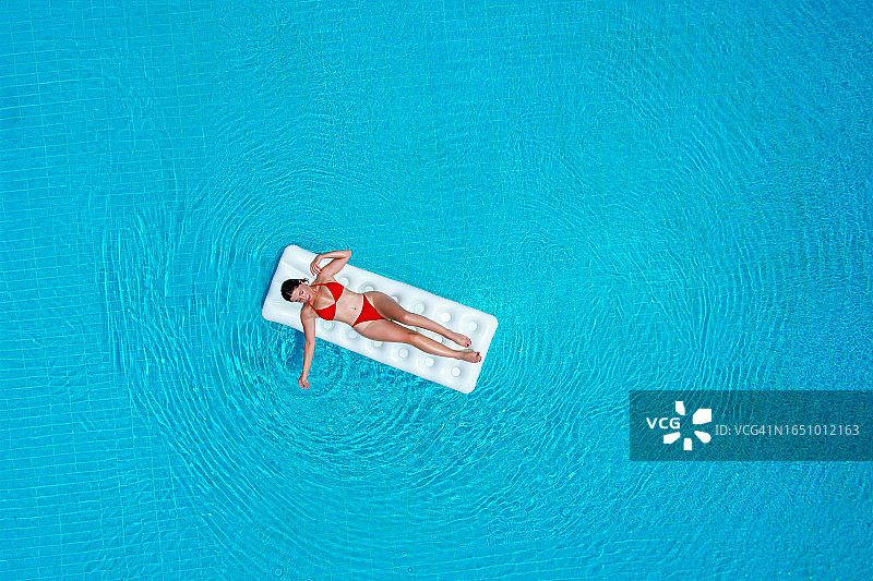 快乐的女人在海床上晒日光浴。图片素材