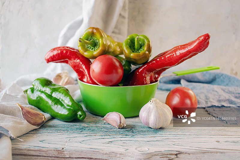木制背景上五颜六色的蔬菜。胡椒粉，西红柿，大蒜用来做饭图片素材