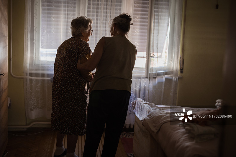 家庭护工在家里帮助一位老年妇女的护士图片素材