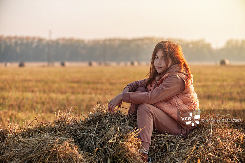 可爱的少女站在麦穗和干草堆旁早上好，福格图片素材