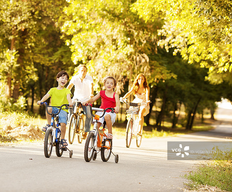欢乐的家庭在户外骑自行车。图片素材