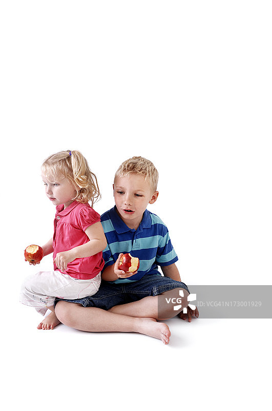 在她哥哥的膝盖上吃苹果图片素材