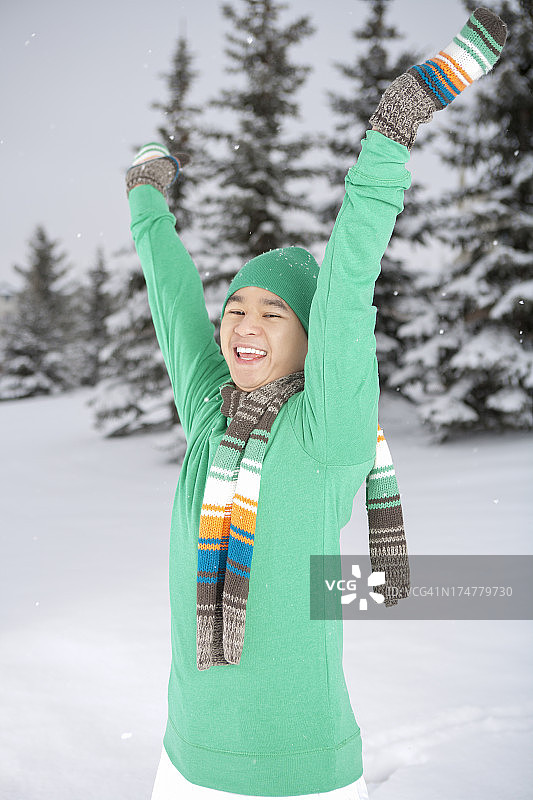 冬季微笑的亚洲男人举起手臂图片素材