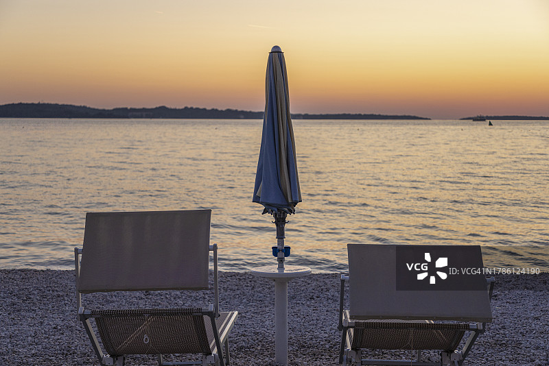 日落时分，沙滩上空荡荡的桌椅映衬着天空图片素材