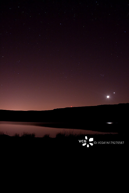 夜晚拍摄的湖与月亮和土星图片素材