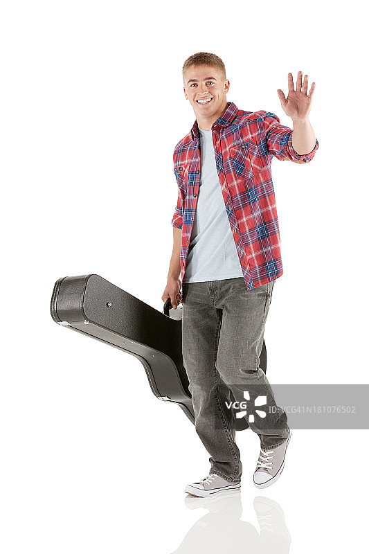 一个手拿吉他走路的人图片素材