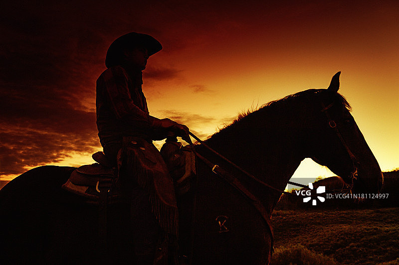 牛仔在他的马在西部日落-剪影图片素材