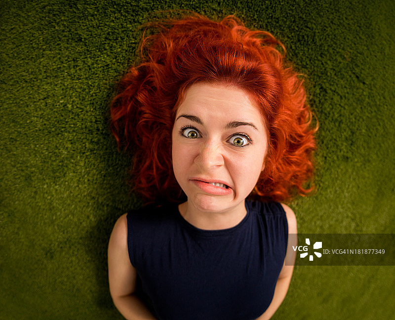 草地上的红头发女孩看起来很滑稽图片素材