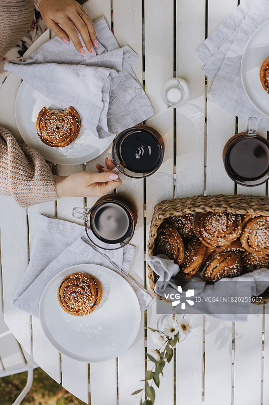 木桌上的咖啡杯和肉桂面包的高角度视图图片素材