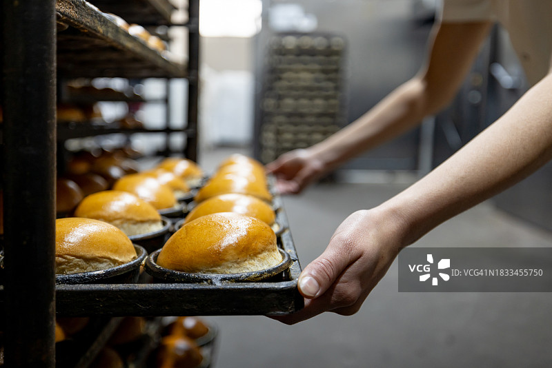 面包师在面包店烤面包的特写镜头图片素材