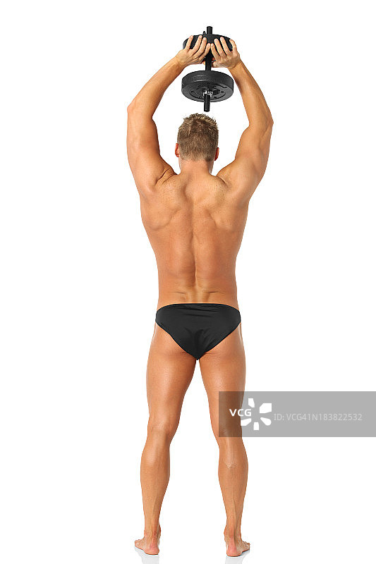 一个男人用哑铃锻炼的后视图图片素材