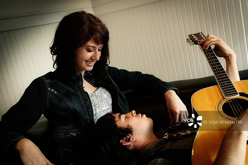 浪漫的年轻情侣放松和弹吉他图片素材