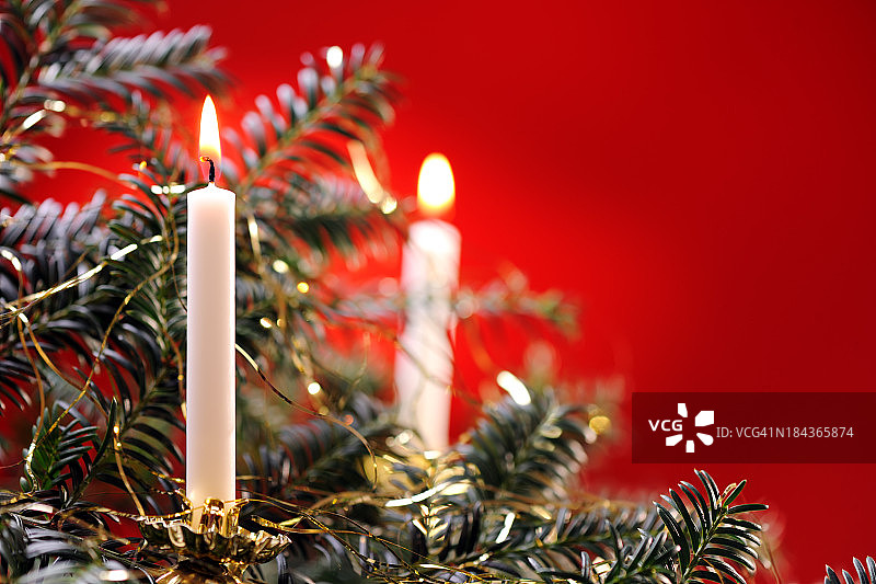 红色背景上的圣诞树和蜡烛图片素材
