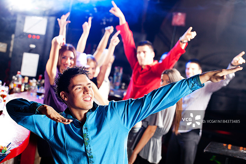 一个年轻人在迪斯科俱乐部跳舞。图片素材