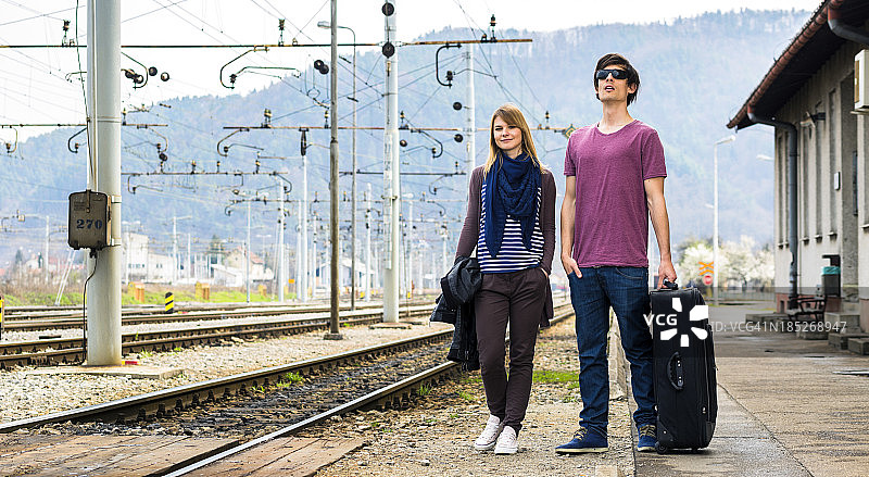一对年轻夫妇在火车站等候图片素材