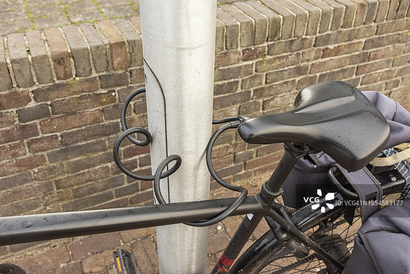 黑色鞍座的男子自行车用黑色挂锁锁着图片素材