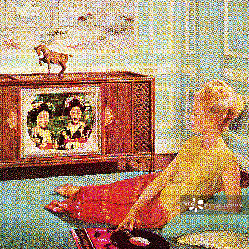 在蓝色房间里看电视的女人图片素材