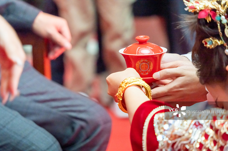 在传统的中国婚礼上，新娘和新郎向长辈敬茶图片素材