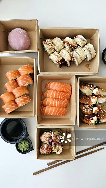 什锦寿司选择在外卖盒。各式寿司卷装在环保外卖盒里，带筷子。图片素材