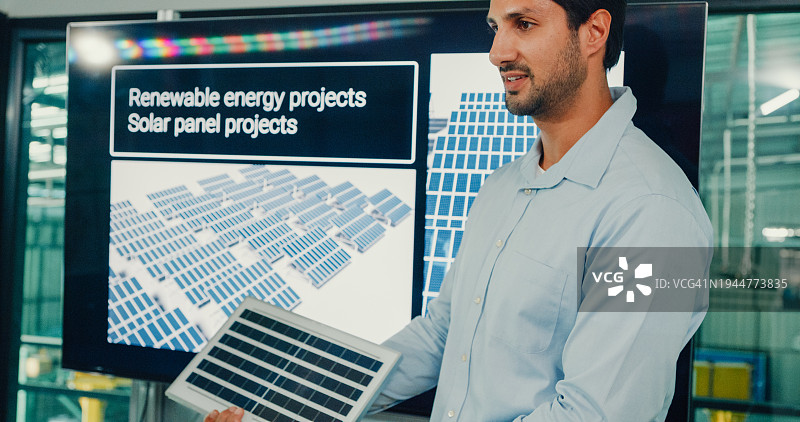 可再生能源工业工程师会议的特写团队，在制造工厂致力于创新更高效的太阳能电池板电池。工程和可持续生产工厂。图片素材